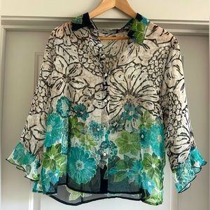 Neutral sheer floral blouse with pops of blue and green.